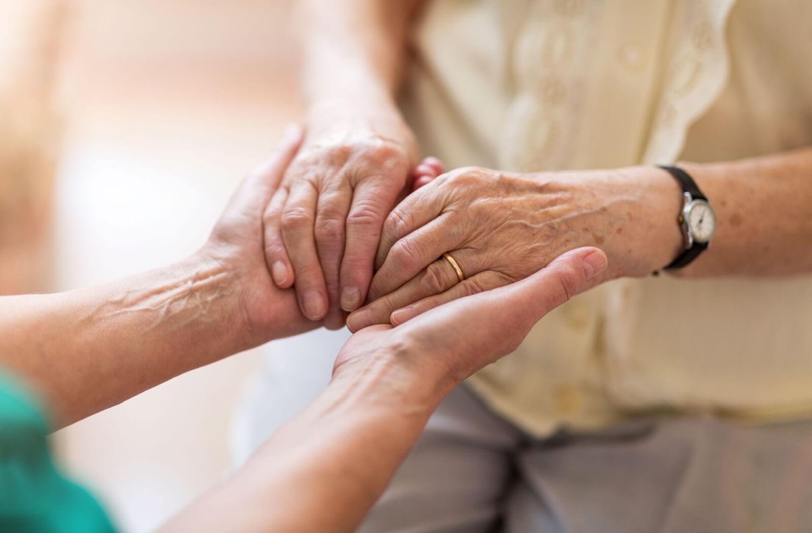caregiver holding hands of senior with dementia